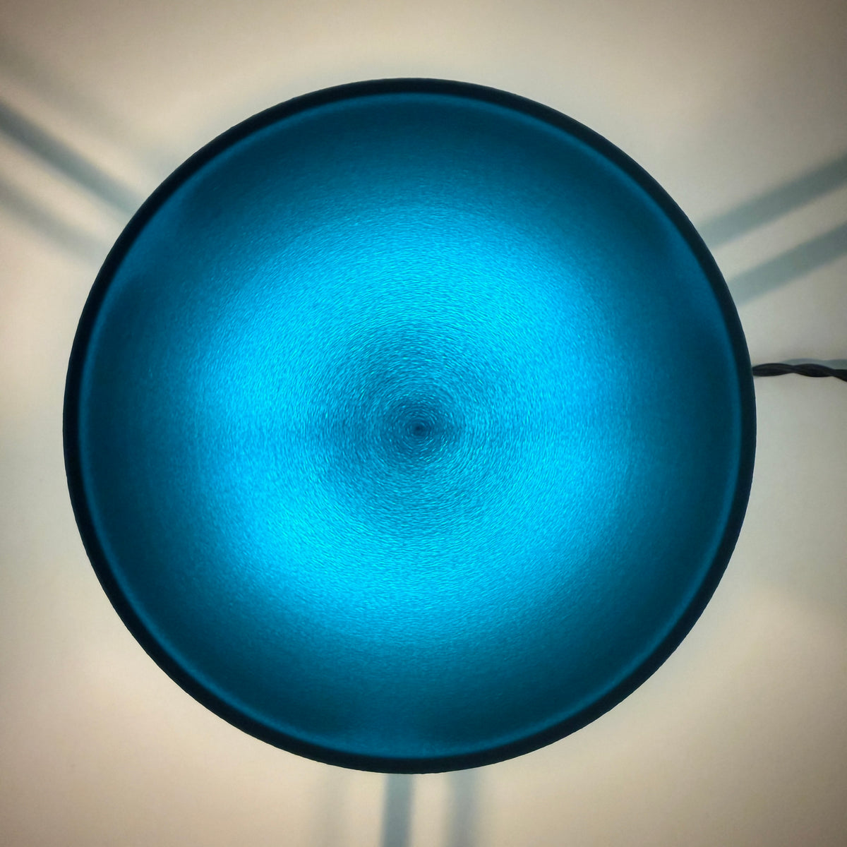 The pale blue cap from directly above, light spreading from the centre to a soft dark rim