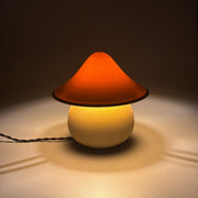 MOSS Desert lit on a pale surface, its sandy cap glowing amber above the rounded base