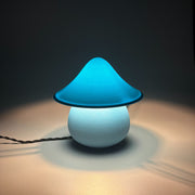 MOSS Ice lit on a pale surface, its pale blue cap glowing warm above the rounded base